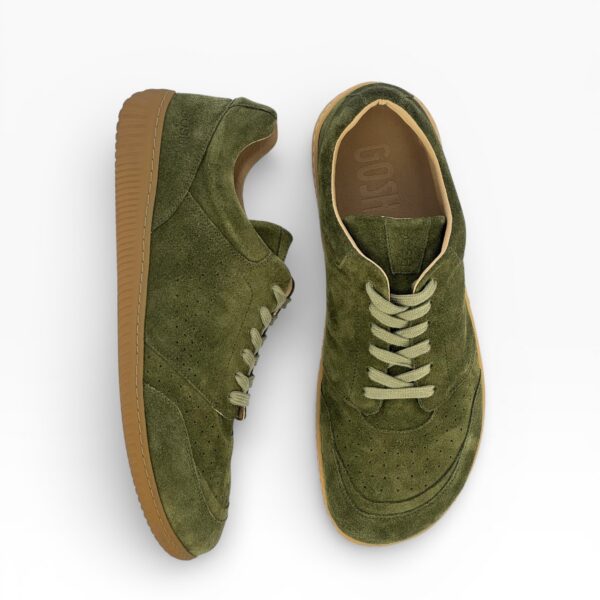 Side-top view of a barefoot green suede shoe