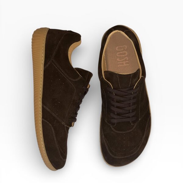 Side-top view of a barefoot brown suede shoe