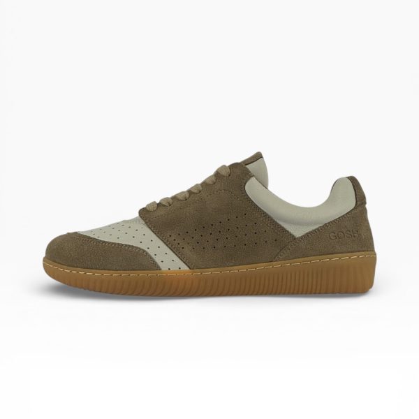 Side profile of a barefoot beige-white suede shoe